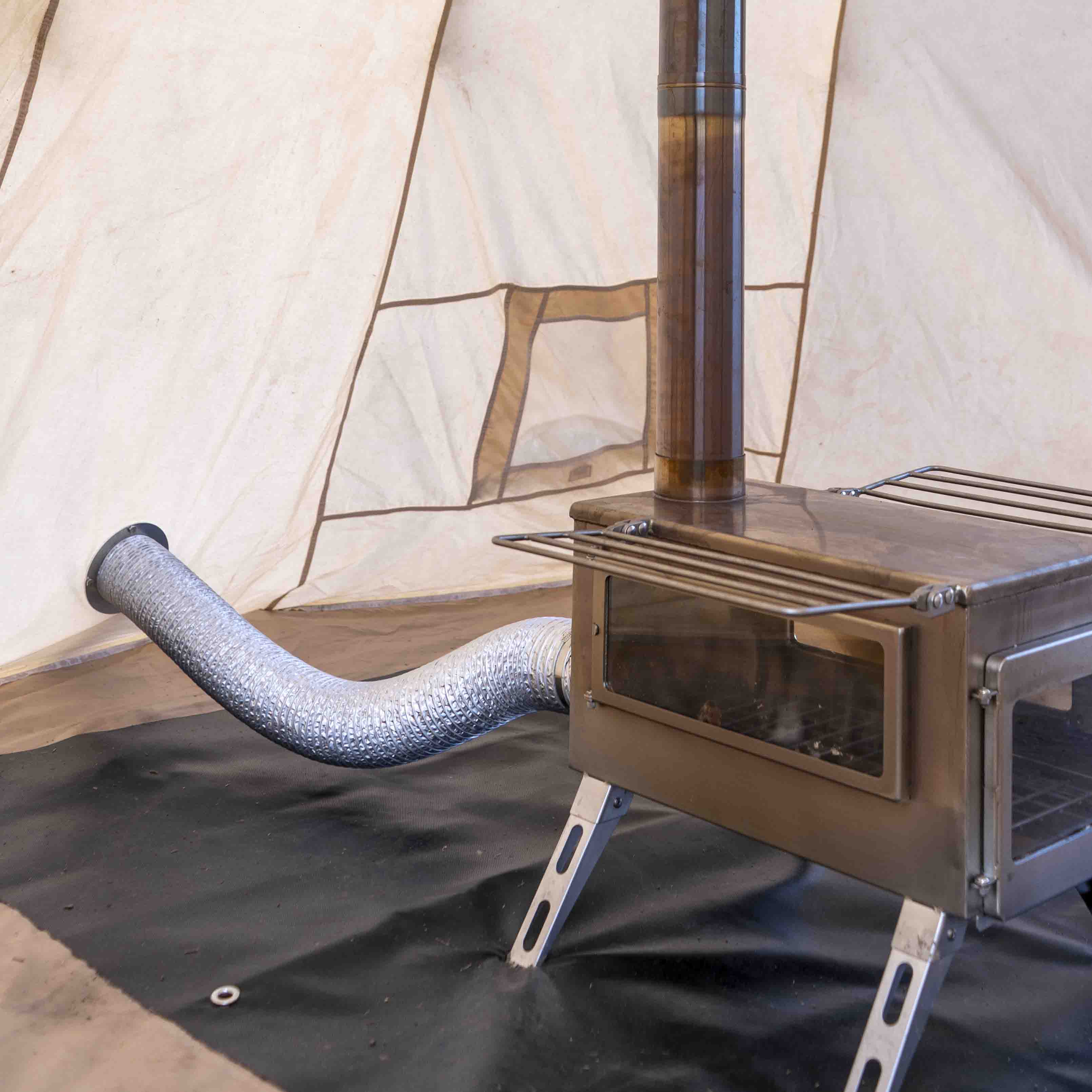 Winnerwell® M - sized Opener & Seal Set integrated with an M - sized stove and tent setup, highlighting its role in creating a proper seal for efficient and safe stove operation during camping.