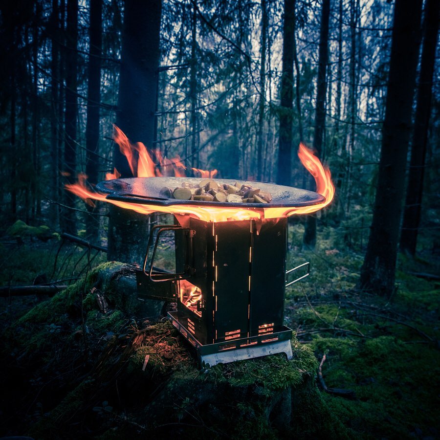 Winnerwell® Mini Multi - functional BBQ Smoker in outdoor use, burning wood/twigs to create heat for smoking meats, grilling food, or as a fire pit. Showcases its rugged design for camping, hiking, and off - grid cooking experiences.