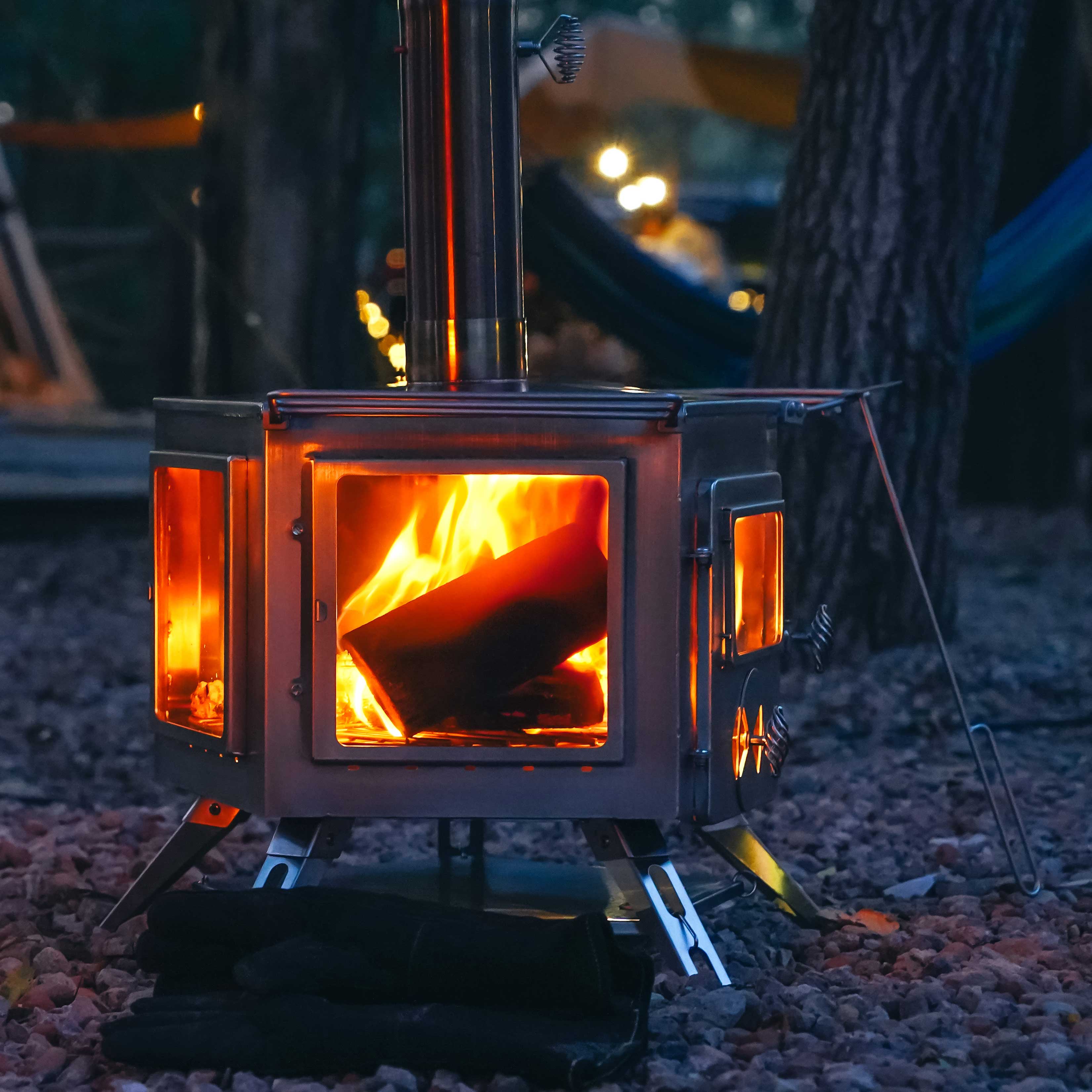 Winnerwell® Pentagon Stove in outdoor use, burning wood to create heat for warming, cooking meals. Showcases its rugged, pentagon - shaped design suitable for camping, hiking, and cold - weather outdoor experiences.
